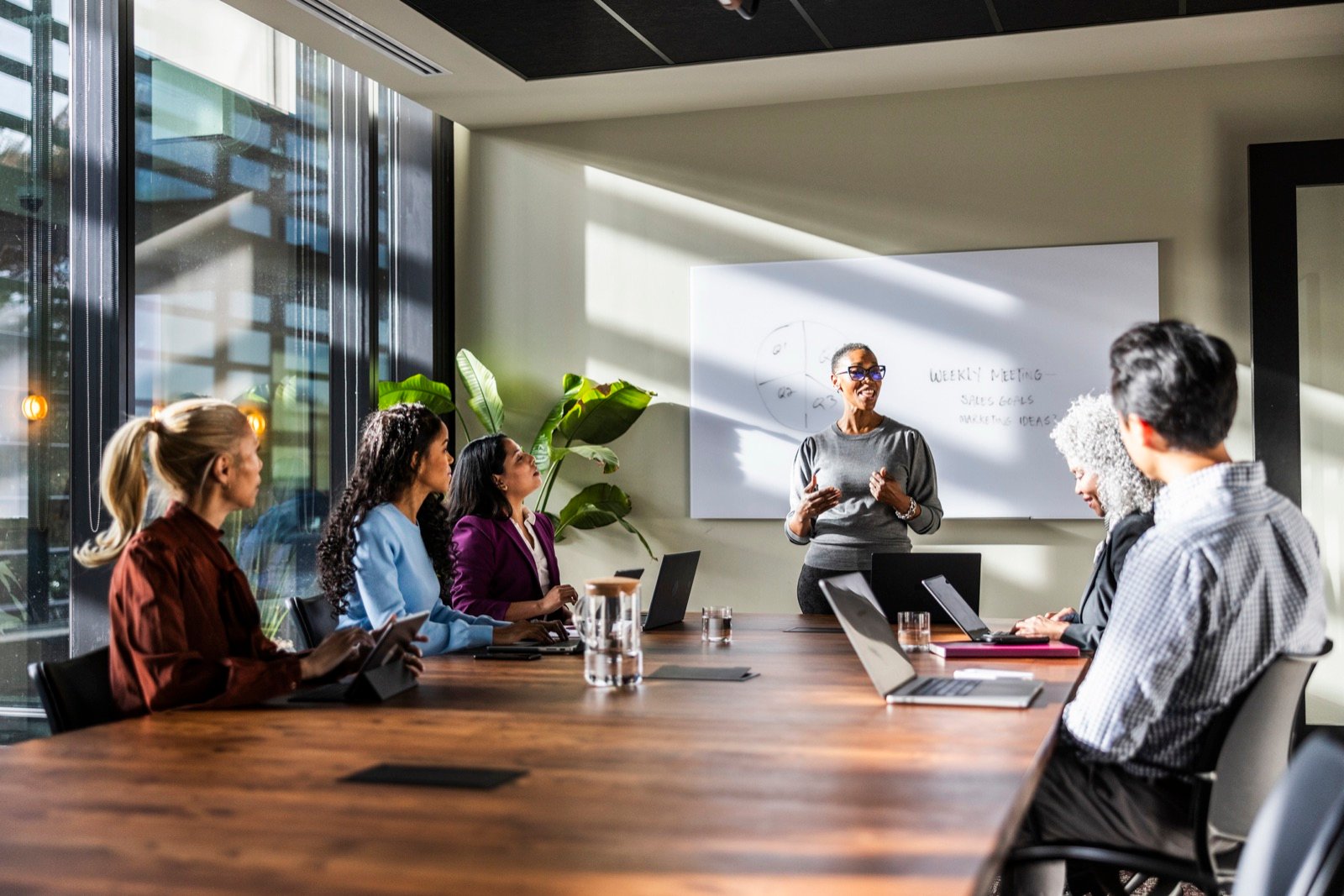 A leader facilitating a session with a team around a boardroom table