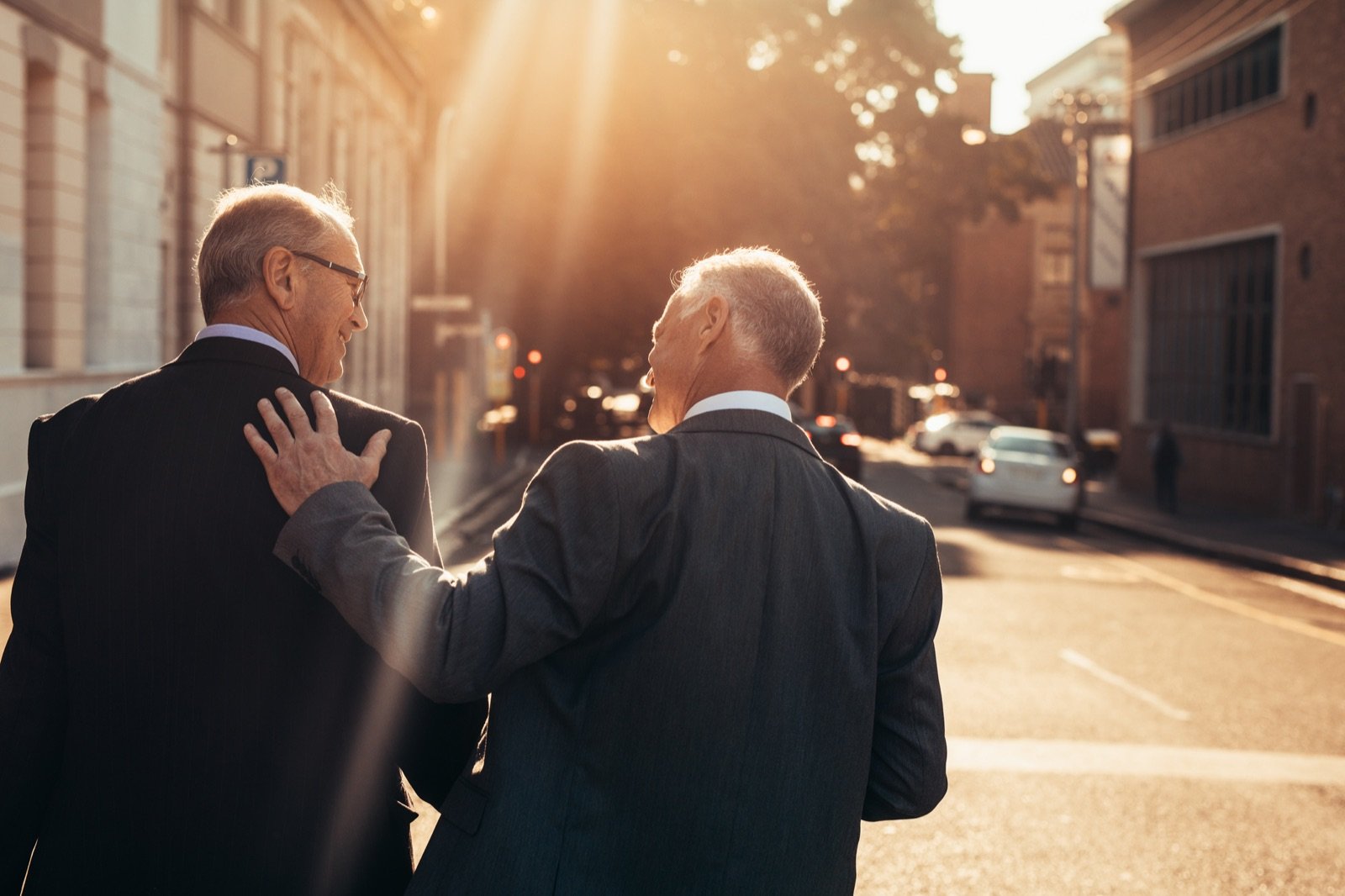 Two senior executives walking and talking in evening light